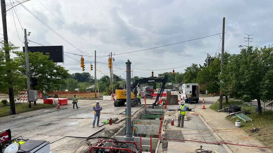 Crews working a distribution pipeline crossing in a city street