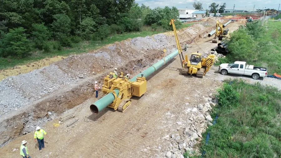 Union crews lowering a welded pipeline into the trench
